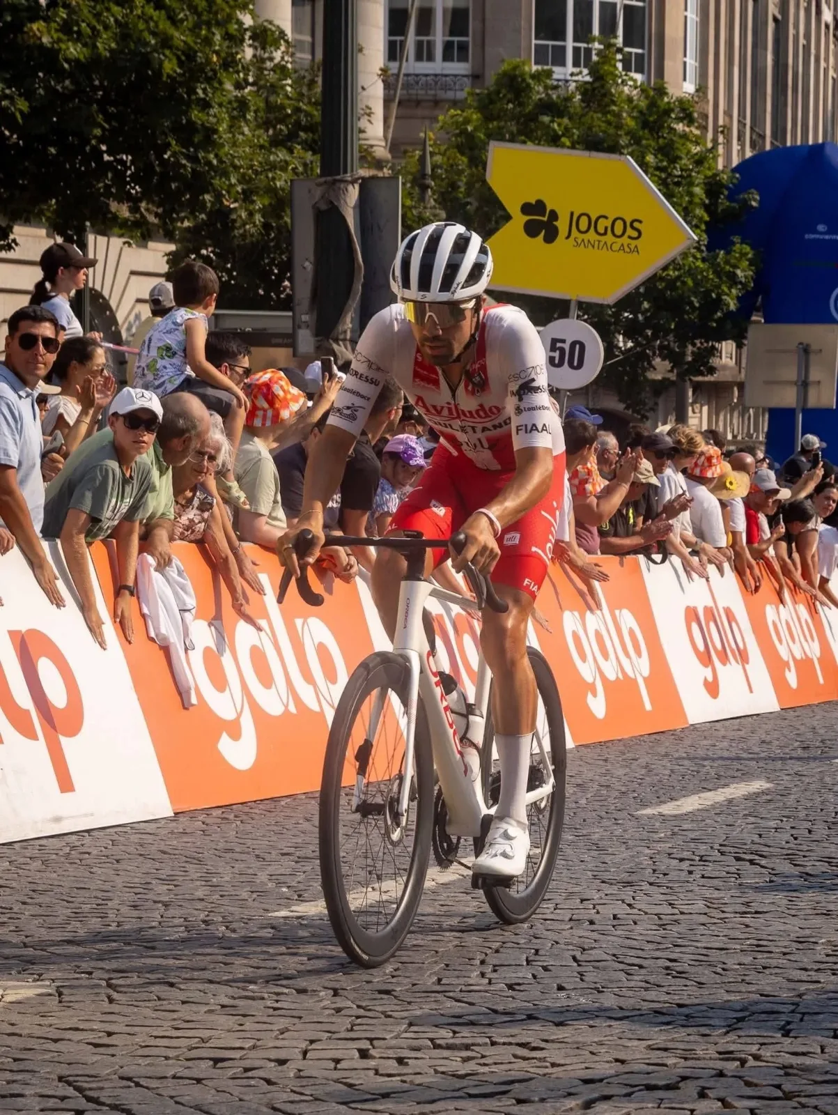 Daniel Viegas riding solo through crowds at a Volta a Portugal finish line